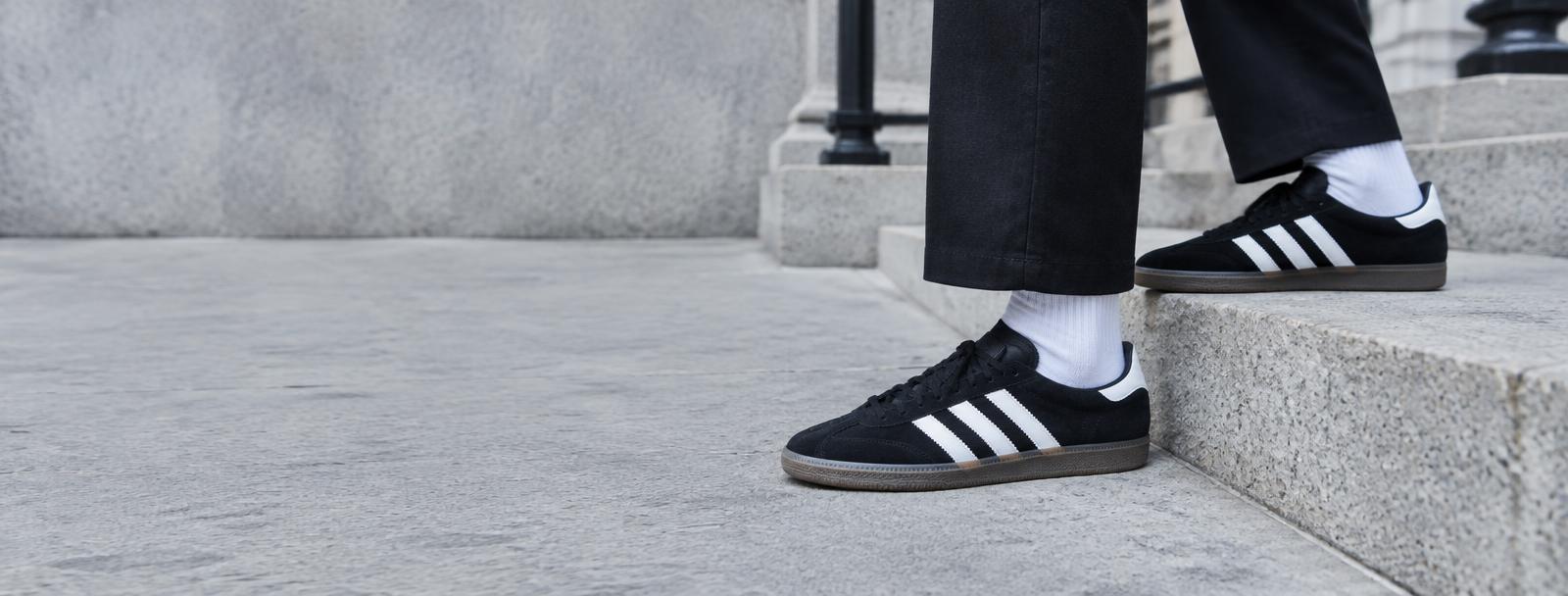 Black and white trainers styled on a city street